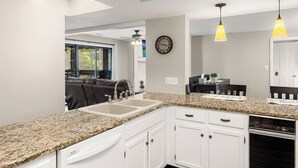 A kitchen with granite countertops, white cabinetry, a built-in oven, and pendant lighting. - Knolls 0424 - Three Bedroom Apartment, Sleeps 8 (Osage Beach)