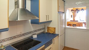 A kitchen with a stove, oven, and cabinets. - Casa La Isleta     . (Níjar)