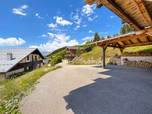 A rural mountain road leading to a wooden cabin with a sloped roof, surrounded by greenery and a clear sky. - Cozy ski-in/ski-out apartment, perfect for 6-8 people with terrace (Notre-Dame-de-Bellecombe)