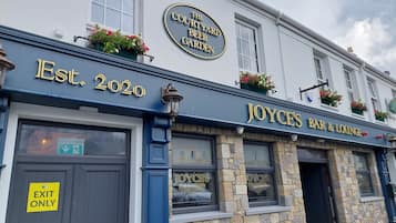 A building with a sign reading "The Court Yard Beer Garden" and "Joyce's Bar & Lounge" established in 2020.