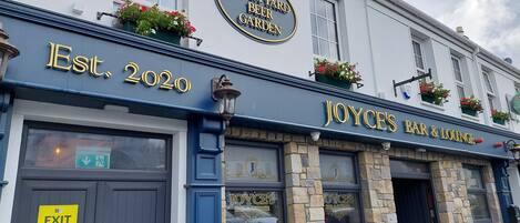 A building with a sign reading "The Court Yard Beer Garden" and "Joyce's Bar & Lounge" established in 2020.