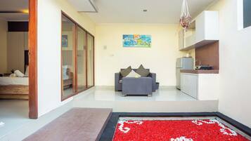 A modern living area with a sofa, a dining table, and a kitchen area.
