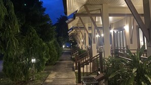 A covered outdoor area with a pathway leading to a building with multiple seating areas. - Chaithalay Khanom Resort (Khanom)