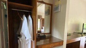 A bathroom with a wooden vanity, a mirror, and a towel rack with white towels. - Chaithalay Khanom Resort (Khanom)