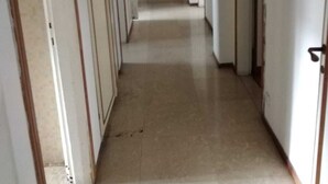 A narrow hallway with doors on both sides, a bench in the center, and a hanging light fixture. - Florence Hostels Anamaria (Florence)