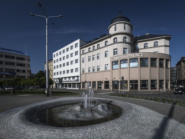 Rakennuksen edessä on suihkulähde, ja rakennuksessa on kyltti, jossa lukee: ”Kampus-palatsi”.