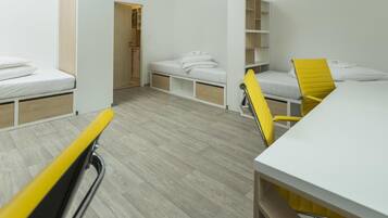 Una habitación pequeña con cama, escritorio y silla.