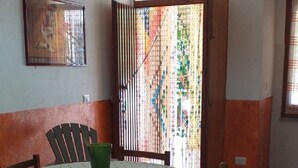Een eetgedeelte met een ronde tafel, stoelen en een hanglamp.