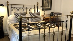 A bed with a metal frame, a quilt, and two patterned pillows.
