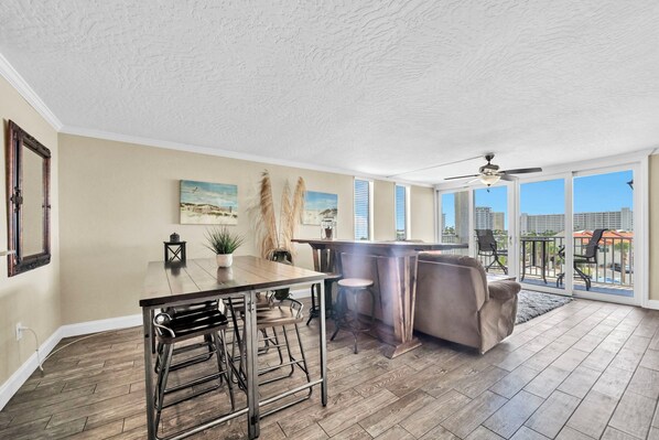 A spacious kitchen with a bar area, large windows, and a view of the city. - Renovated 2 Bedroom 2 Bath on the Harbor (Destin)