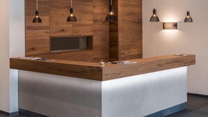 A modern kitchen with a wooden island, pendant lights, and built-in cabinetry. - Eden Boutique Hotel (Curon Venosta)