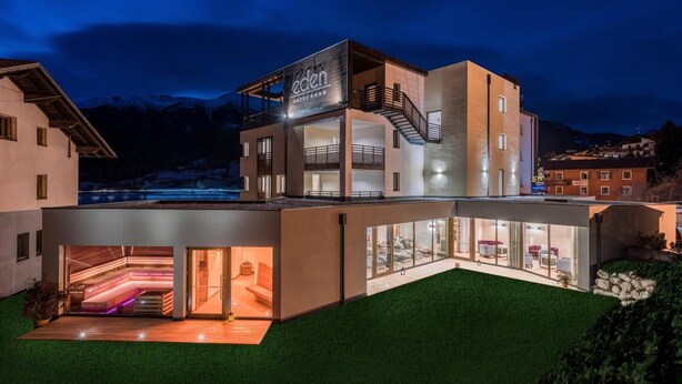 A modern hotel with a glass facade, a visible staircase, and a sign reading "eden HOTEL". - Eden Boutique Hotel (Curon Venosta)