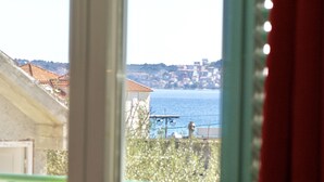 Blick durch ein Fenster auf eine Küstenstadt mit Gebäuden und einem Gewässer.