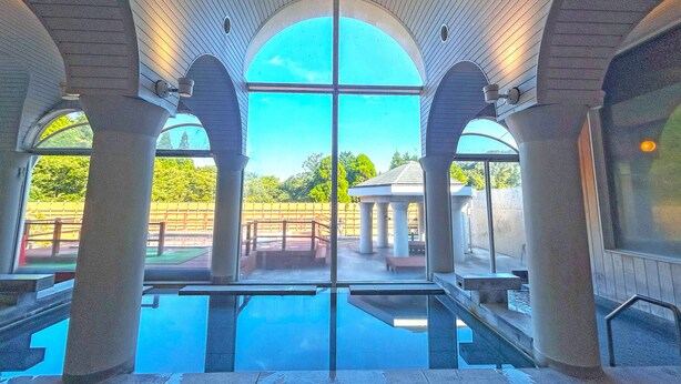 A pool area with clear glass walls, a view of the outdoors, and a gazebo in the background. - Kutsuroginomori Greenpia Yame (Yame)