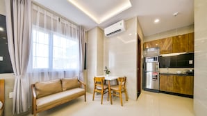 A modern kitchen with a built-in microwave, refrigerator, and a small dining area with a table and chairs.