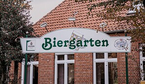 A sign for Biergarten with a beer glass illustration, a logo for Mausel's Weiss, and a Veltins logo. - Hotel Biedendieck (Warendorf)