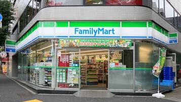 A FamilyMart store with a clear entrance, visible shelves stocked with products, and a sign indicating an ATM.