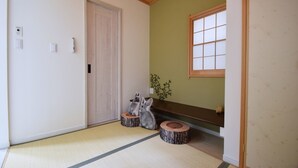 Ein traditioneller japanischer Raum mit Tatami-Bodenbelag, einem Shoji-Bildschirm und einer Holztür.