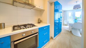 A modern kitchen with blue cabinets, a gas stove, and a built-in oven. - Villa Vinodol (Kvarner - Novi Vinodolski) (Novi Vinodolski)