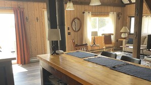 Eine Holz-Küche mit Kochinsel, Einbauschränken und Pendelleuchten.