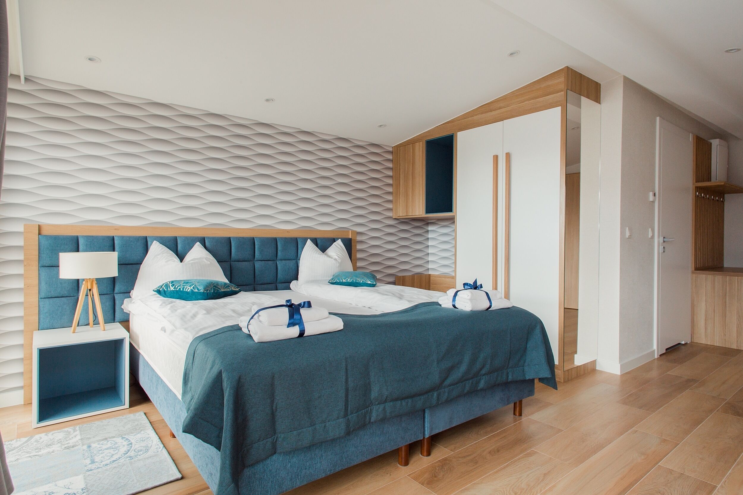 Un dormitorio moderno con cama, mesitas de noche y un armario.