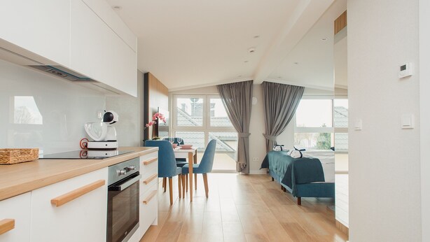 A modern kitchen with a dining area and a balcony.
