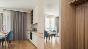 A modern kitchen with wooden cabinets and a dining area with blue chairs.
