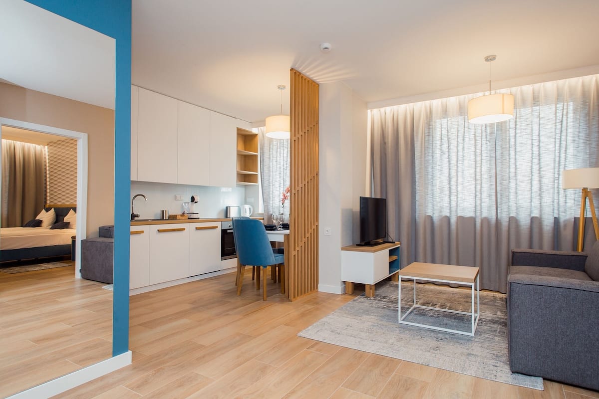 A modern apartment with a living room, kitchen, and dining area.