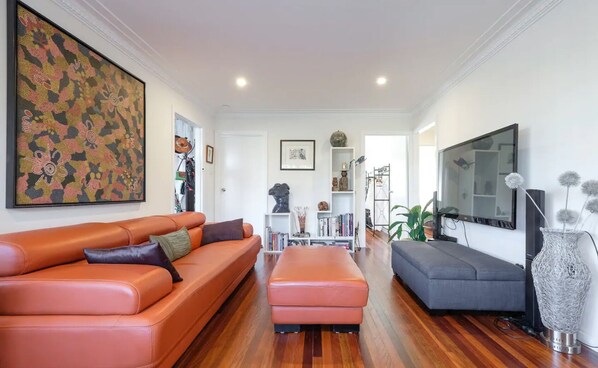 Relax in this stylish living room with a large sofa, sectional sofa, and flat-screen TV.