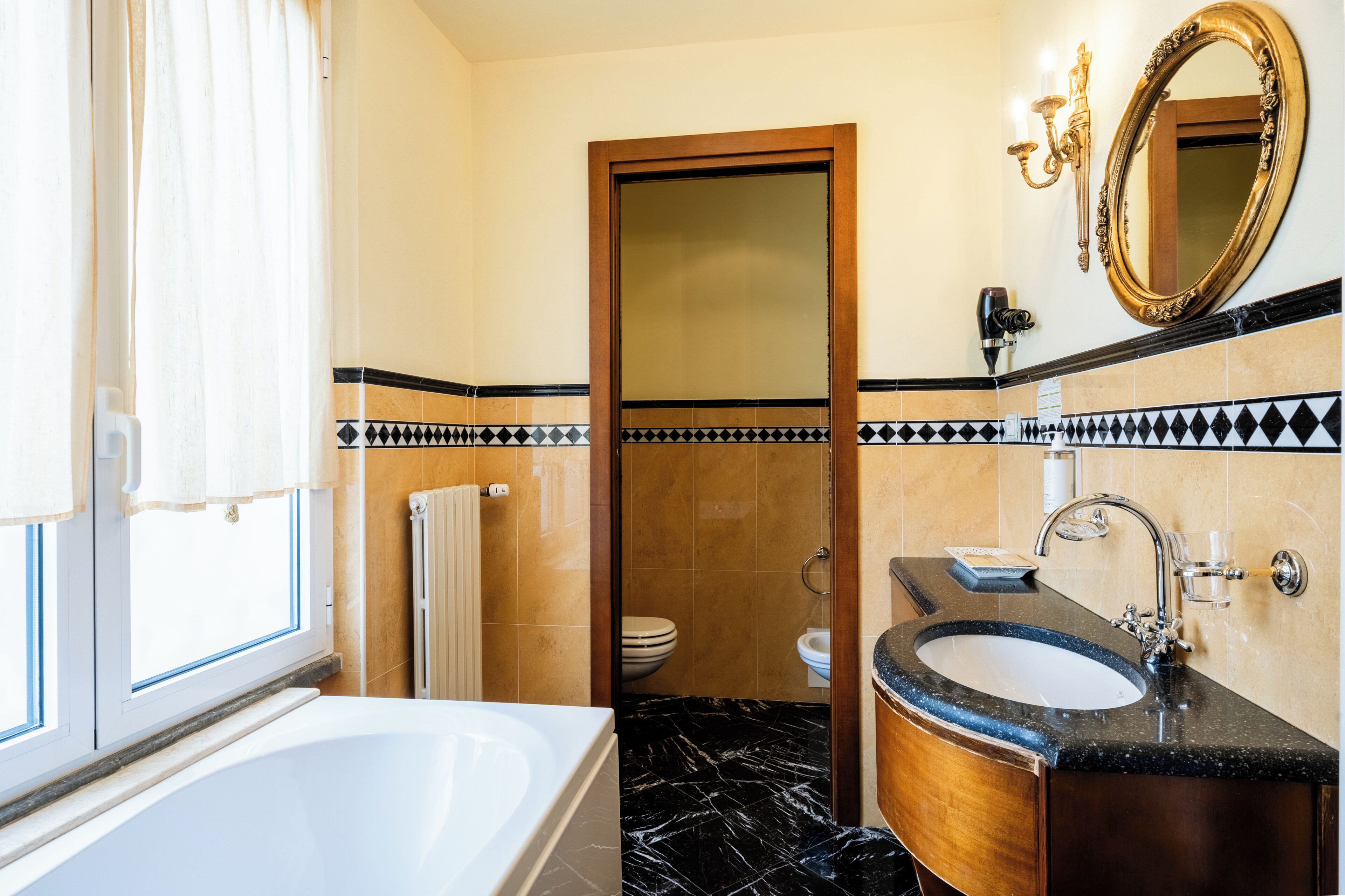 A bathroom with a bathtub, sink, mirror, and toilet.