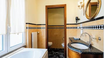 Ein Badezimmer mit Badewanne, Waschbecken, Spiegel und Toilette.