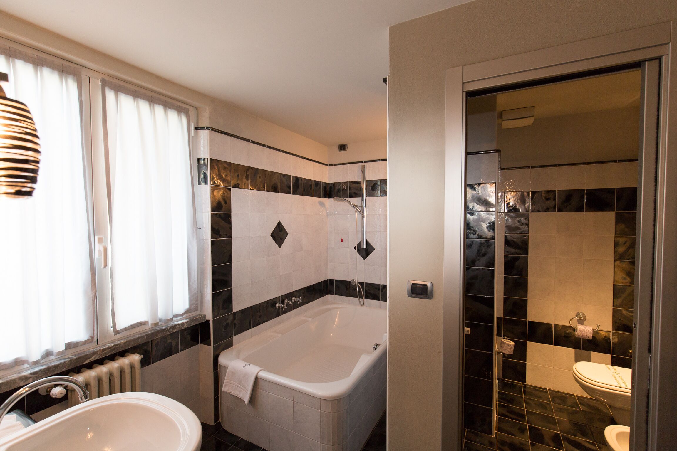 Un baño con bañera, lavamanos e inodoro.