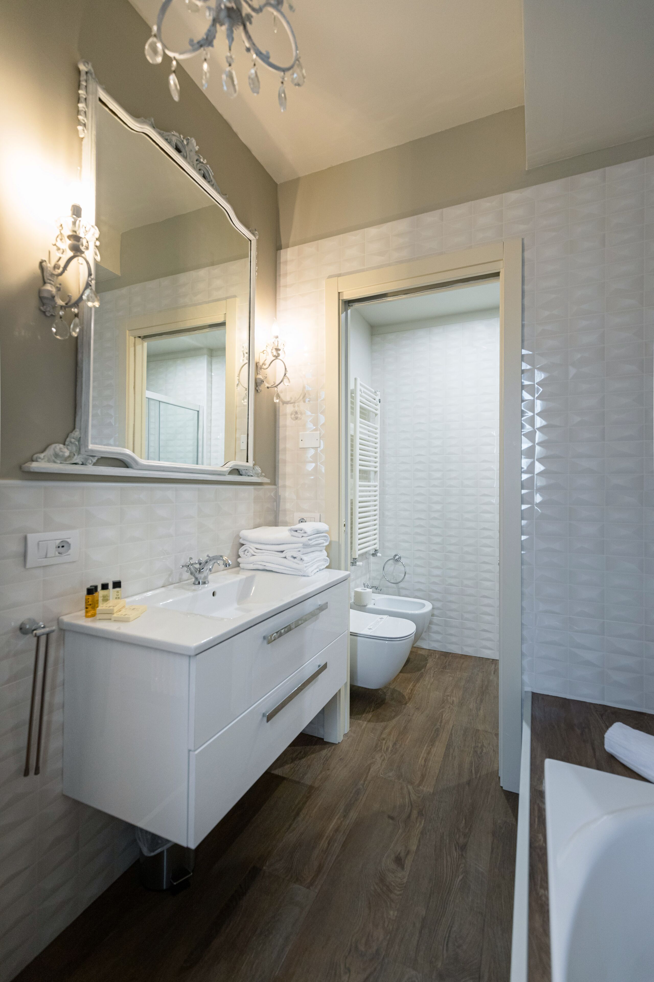 Un baño moderno con un espejo grande, dos lavamanos, un inodoro y una zona de ducha.