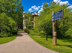 A pathway leading to a building with a signpost indicating directions to The Charter, Toward Place/Crescide, and Eldhorn Life/Lodge. - Townsend Place Condo 3 minutes walk to Beaver Creek VIllage by RedAwning (Avon)