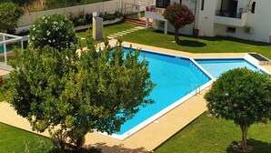 A residential area with a swimming pool surrounded by well-maintained lawns and trees. - OURASOL 2 Bedroom Apartment in Santa Eulalia, Albufeira Centre  (Albufeira)
