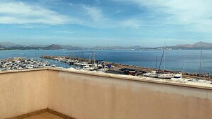 A marina with boats docked, a clear sky, and distant mountains. - Minimal, sea views apartment first line (Santa Margalida - Can Picafort/Son Serra Marina)