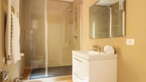 A modern bathroom with a toilet, sink, and shower area.