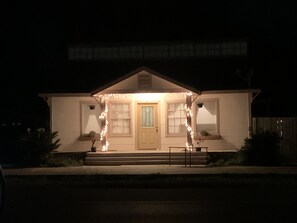Een huis met een veranda, een deur en treden die naar de ingang leiden.