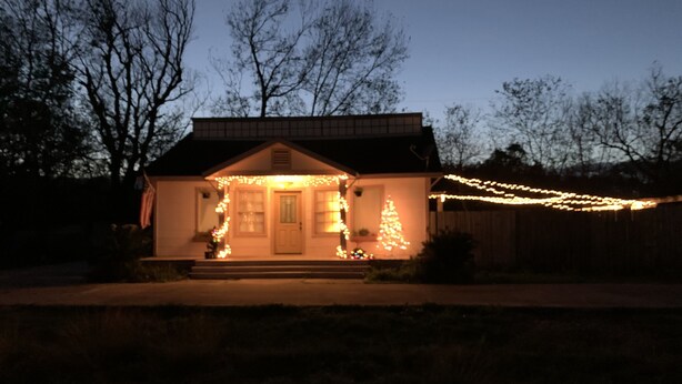 A house with a front porch decorated with lights and a Christmas tree. - SHOTGUN HOUSE (Angleton)