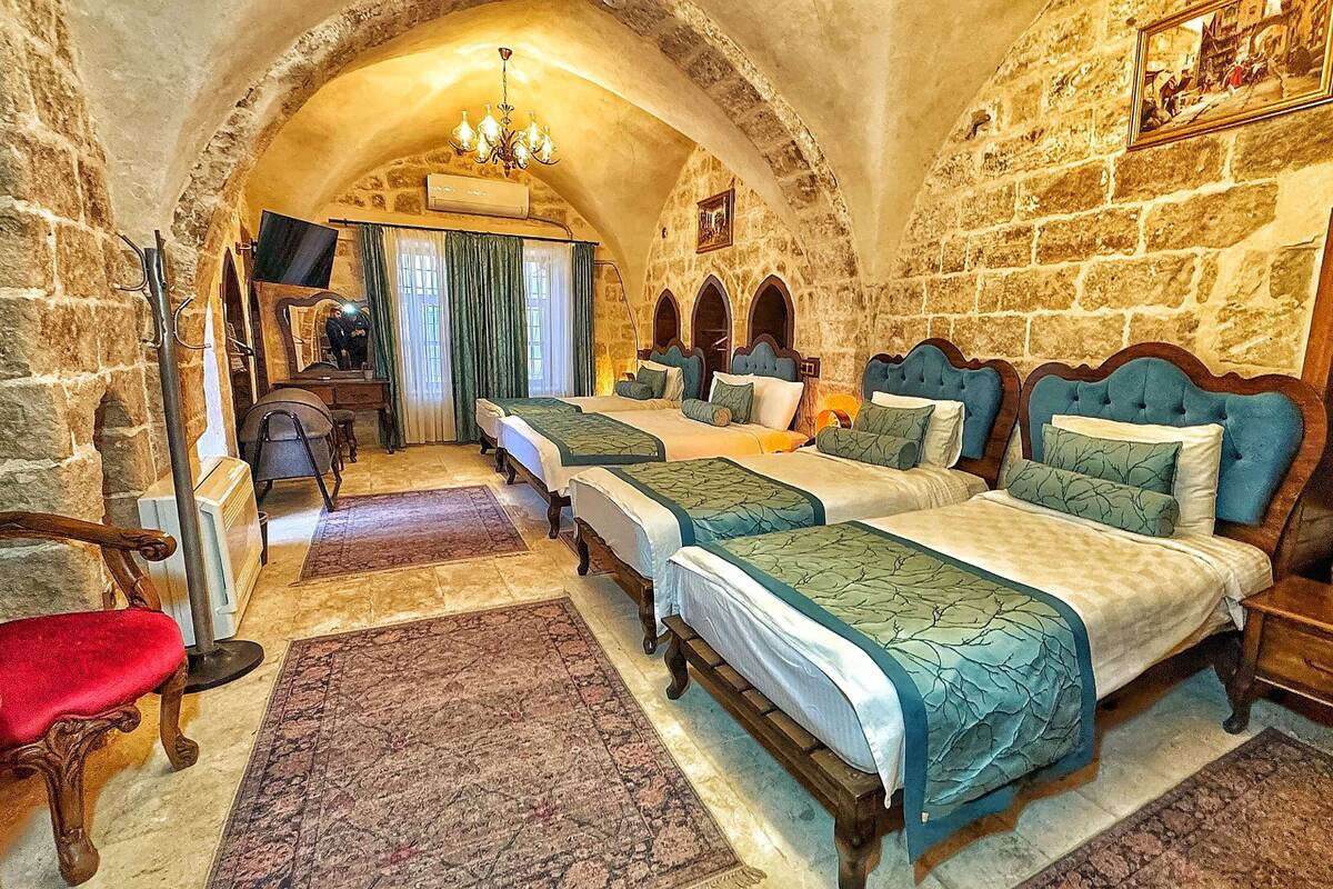 A room with four beds, a desk, and a chair.