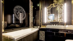 Un baño moderno con una bañera grande, un lavamanos independiente y un inodoro.