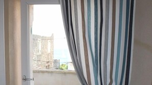 Una habitación con vista a un patio empedrado y un edificio al fondo.