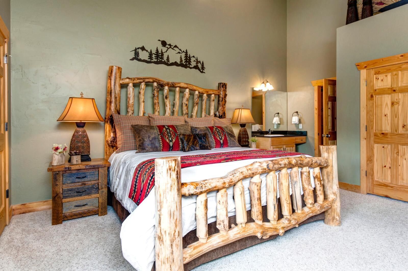 A bedroom with a rustic wooden bed frame, a nightstand with a lamp, a dresser, and a wall-mounted mirror.
