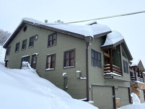 Ein zweistöckiges Haus mit Garage, umgeben von Schnee.