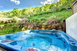 A hot tub with a view of a lush green hillside. - Walk to Ski Slopes + Trails! Spacious 4-Bedroom Private Home with Fantastic Views, Hot Tub, A/C, and Wood Fireplace | PLA-1155 by KBM Resorts (Park City)