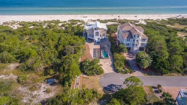 An aerial view of a beachfront property with two large houses, a swimming pool, and a beach in the background. - Private Pool, Elevator, Sleeps 20, Bob Sikes Cut! (St. George Island)