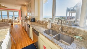 A kitchen with granite countertops, stainless steel sinks, and a view of the ocean. - Private Pool, Elevator, Sleeps 20, Bob Sikes Cut! (St. George Island)