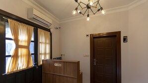 Un'area reception con una scrivania in legno, una porta con un cartello e un lampadario.