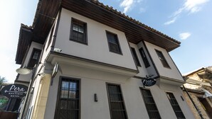 Un edificio a due piani con un cartello che riporta "Pera Boutique Hotel" sulla facciata.