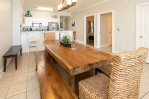 Ein Essbereich mit einem Holztisch, Bänken und Korbstühlen.
